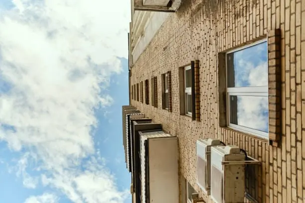 fachada de edificio con unidad exterior de aire acondicionado